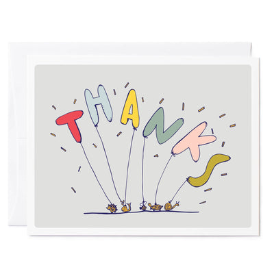 A thank you card featuring bubble balloons spelling out "Thanks" anchored down with animal paper weights.