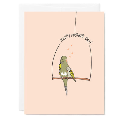 Illustrated pink mother's day greeting card with drawing of green parakeet mom and her baby, hand lettered words read 'Happy Mother's Day'