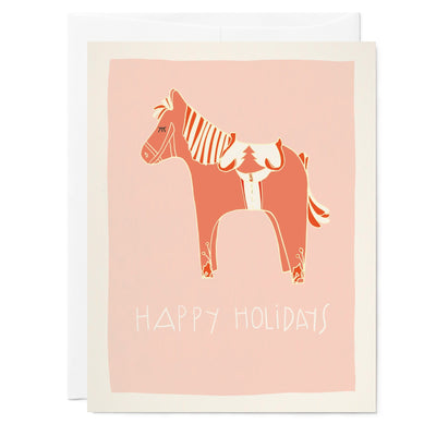 Illustrated holiday greeting card with pink background and drawing of swedish horse, hand lettering text reads 'happy holidays'