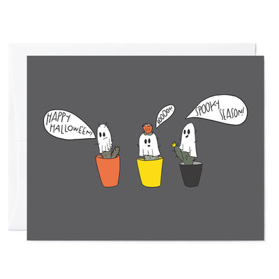 Hand illustrated greeting card of 3 cactus in pots dressed up as little ghosts. Each is saying 'Happy Halloween', 'Booo', and 'Spooky Season!'. Gray bacground.