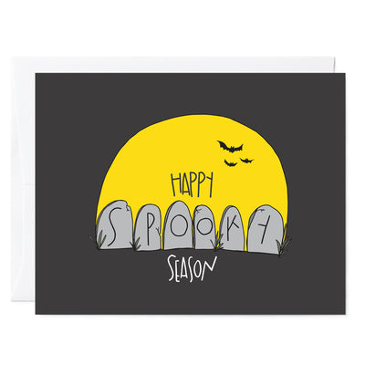 Hand illustrated greeting card with drawing of yellow moon with bats flying in front. 6 gravestone heads, words read 'Happy SPOOKY Season, spooky written out across the graves. Dark gray background.